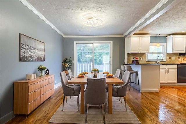 209 Thompson Rd, Henrietta, NY 14623 - dining room featuring wood finished floors, plenty of natural light, a textured ceiling, and crown molding