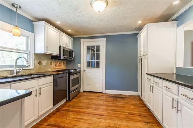 209 Thompson Rd, Henrietta, NY 14623 - kitchen with stainless steel appliances, white cabinets, wood finished floors, decorative backsplash, and dark countertops