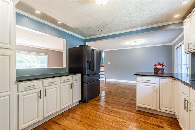 209 Thompson Rd, Henrietta, NY 14623 - kitchen featuring black fridge, a textured ceiling, dark countertops, light wood-style floors, and white cabinets