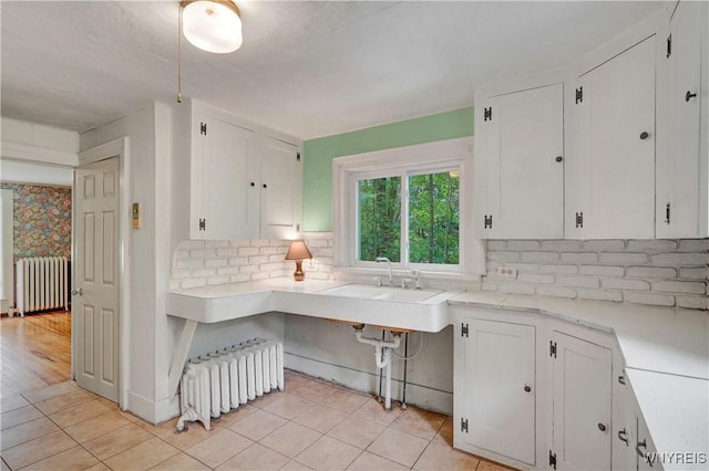 7709 Olean Rd, Holland, NY 14080 - kitchen featuring radiator, white cabinets, and light countertops