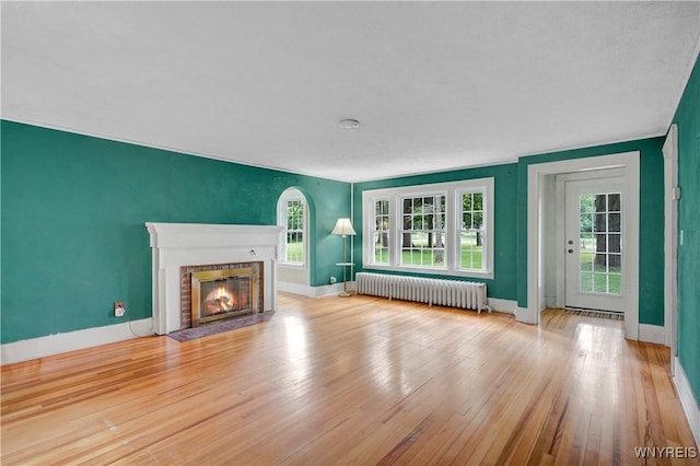 7709 Olean Rd, Holland, NY 14080 - unfurnished living room with radiator, a fireplace, and hardwood / wood-style floors
