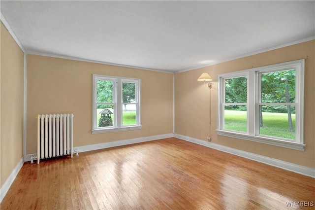 7709 Olean Rd, Holland, NY 14080 - empty room featuring radiator, healthy amount of natural light, light wood finished floors, and ornamental molding