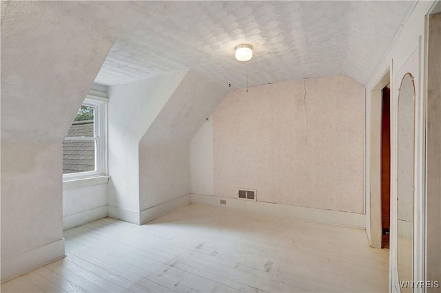 7709 Olean Rd, Holland, NY 14080 - additional living space with vaulted ceiling, hardwood / wood-style floors, and a textured ceiling