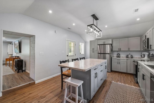 9184 Newcomb Rd, Evans, NY 14006 - kitchen featuring stainless steel appliances, lofted ceiling, gray cabinets, light countertops, and a kitchen breakfast bar
