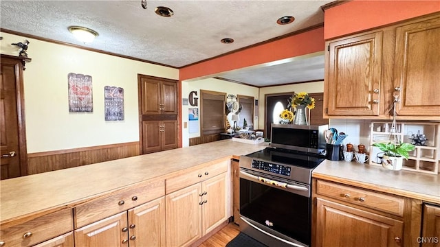 1155 County Route 53, Scriba, NY 13126 - kitchen featuring stainless steel appliances, ornamental molding, light countertops, a textured ceiling, and light wood-type flooring