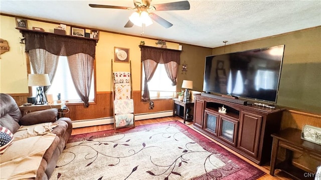 1155 County Route 53, Scriba, NY 13126 - living area featuring light wood finished floors, a wainscoted wall, a baseboard radiator, ceiling fan, and crown molding
