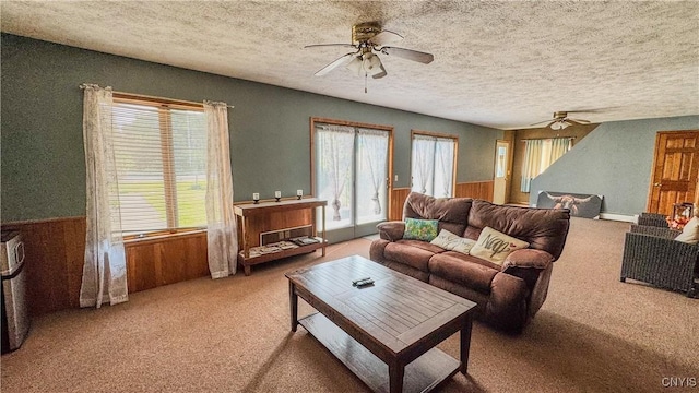 1155 County Route 53, Scriba, NY 13126 - carpeted living room featuring a ceiling fan, wainscoting, a textured ceiling, wood walls, and a baseboard heating unit