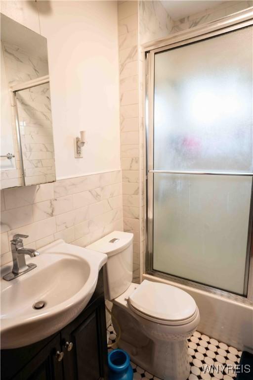 14 Phyllis Ave, Buffalo, NY 14215 - full bath with vanity, tile walls, and combined bath / shower with glass door
