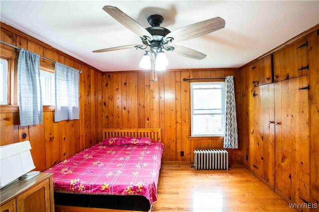 14 Phyllis Ave, Buffalo, NY 14215 - bedroom featuring radiator heating unit, light wood-style floors, wooden walls, and ceiling fan