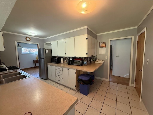 5 Breen St, Mount Morris, NY 14510 - kitchen with freestanding refrigerator, white cabinets, light tile patterned floors, light countertops, and crown molding