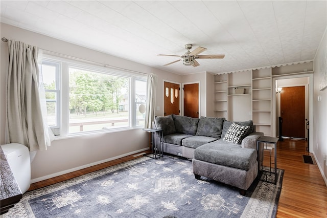 183 Castle Rd, Henrietta, NY 14623 - living room with wood finished floors, ceiling fan, and built in shelves