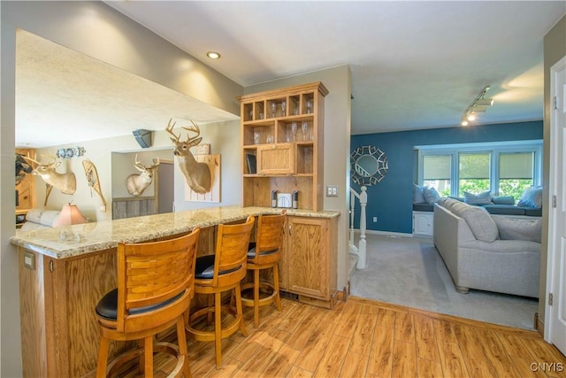 4043 Libra Ln, Clay, NY 13090 - kitchen featuring light wood-style flooring, light stone counters, open floor plan, a breakfast bar area, and open shelves