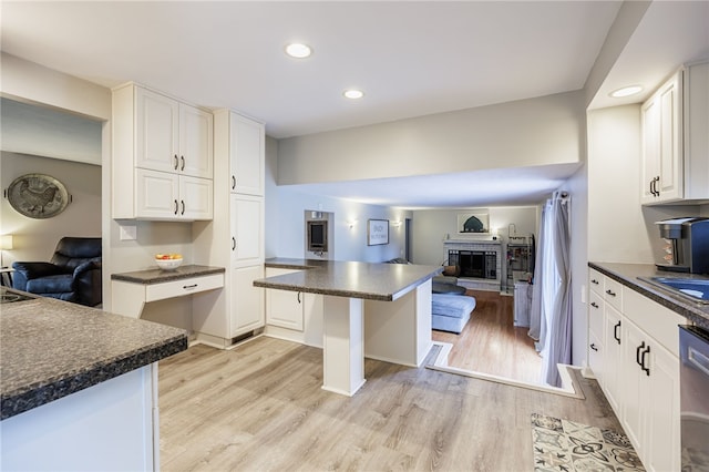 131 Cindy Ln, Greece, NY 14626 - kitchen with dark countertops, open floor plan, a brick fireplace, light wood finished floors, and recessed lighting