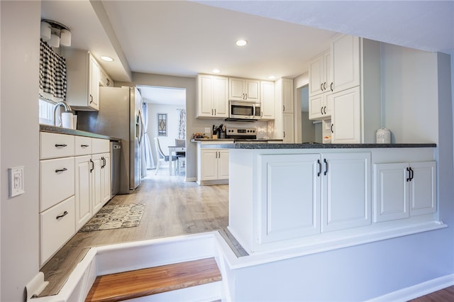 131 Cindy Ln, Greece, NY 14626 - kitchen featuring stainless steel appliances, white cabinets, a peninsula, light wood-style floors, and recessed lighting