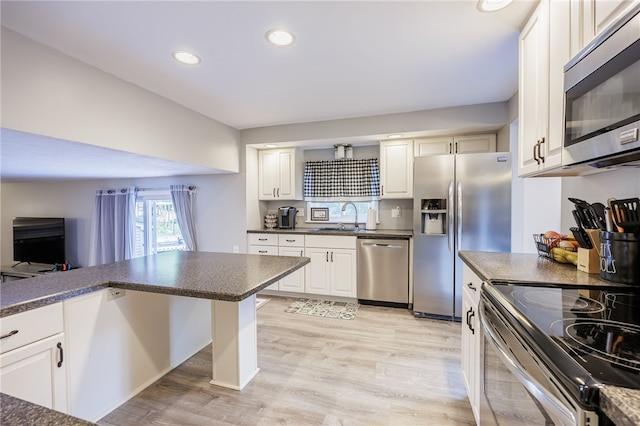 131 Cindy Ln, Greece, NY 14626 - kitchen featuring stainless steel appliances, dark countertops, light wood-style flooring, white cabinets, and recessed lighting