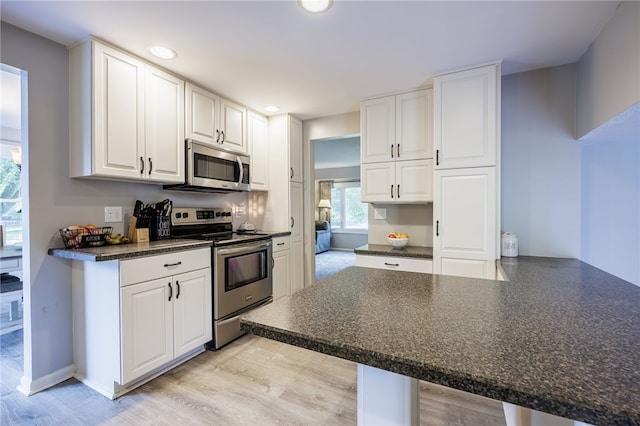 131 Cindy Ln, Greece, NY 14626 - kitchen featuring stainless steel appliances, dark countertops, white cabinetry, recessed lighting, and light wood-style floors