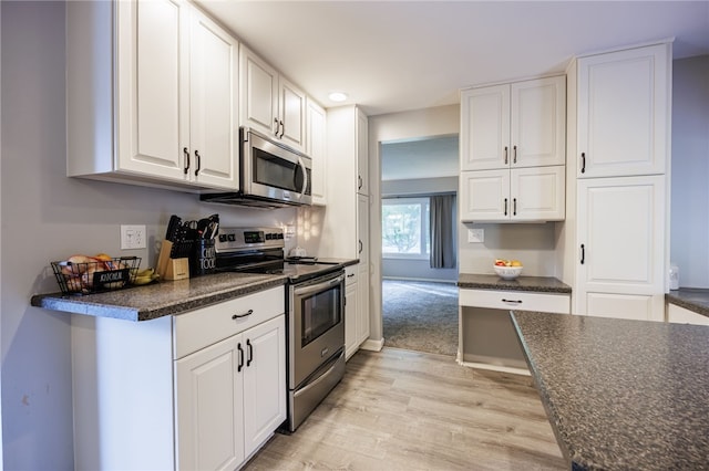 131 Cindy Ln, Greece, NY 14626 - kitchen featuring appliances with stainless steel finishes, dark countertops, light wood-style flooring, white cabinetry, and recessed lighting
