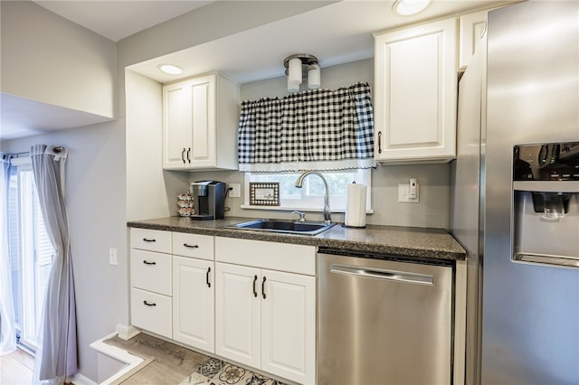 131 Cindy Ln, Greece, NY 14626 - kitchen featuring stainless steel appliances, dark countertops, white cabinets, and light wood-style floors