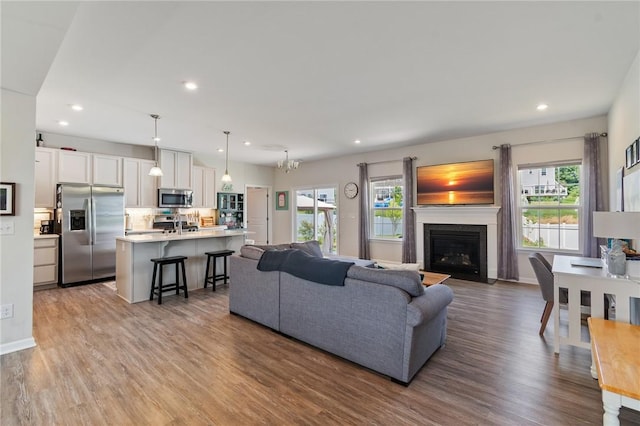 254 Longleaf Ln, Walworth, NY 14502 - living room featuring wood finished floors, a fireplace with flush hearth, and recessed lighting