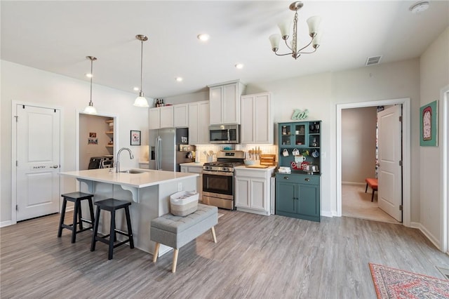 254 Longleaf Ln, Walworth, NY 14502 - kitchen with appliances with stainless steel finishes, a kitchen island with sink, a chandelier, light wood finished floors, and recessed lighting