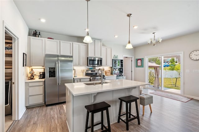 254 Longleaf Ln, Walworth, NY 14502 - kitchen featuring stainless steel appliances, tasteful backsplash, light countertops, light wood-style flooring, and a kitchen breakfast bar