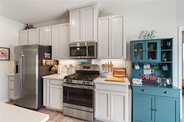 254 Longleaf Ln, Walworth, NY 14502 - kitchen featuring stainless steel appliances, light wood-type flooring, decorative backsplash, light countertops, and white cabinets