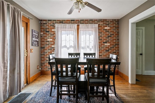67 Pleasant St, Phelps, NY 14532 - dining area featuring wood finished floors, a ceiling fan, and brick wall