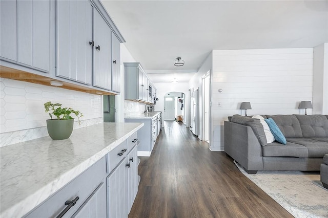 397 Merrill Pl, Southport, NY 14904 - kitchen with open floor plan, dark wood-style floors, arched walkways, decorative backsplash, and light stone countertops