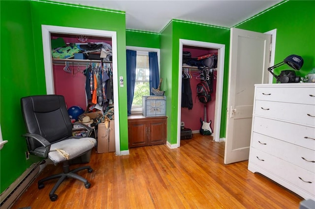 130 Stark Ave, Milo, NY 14527 - bedroom with a baseboard heating unit, wood finished floors, and two closets