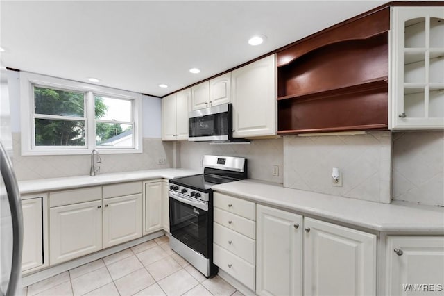 23 Lombardy St, Lancaster, NY 14086 - kitchen featuring appliances with stainless steel finishes, open shelves, white cabinetry, light countertops, and tasteful backsplash
