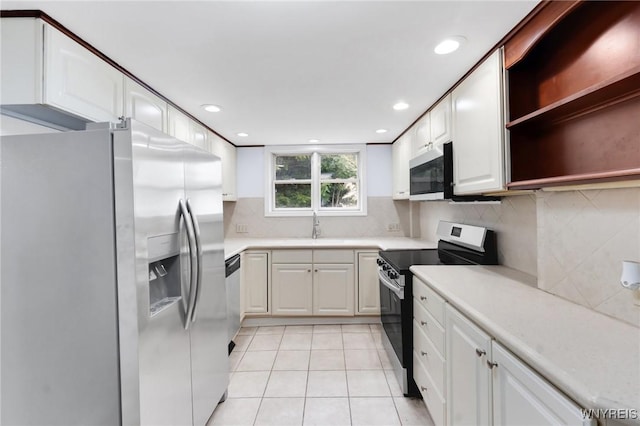 23 Lombardy St, Lancaster, NY 14086 - kitchen with appliances with stainless steel finishes, light tile patterned floors, tasteful backsplash, light countertops, and white cabinetry