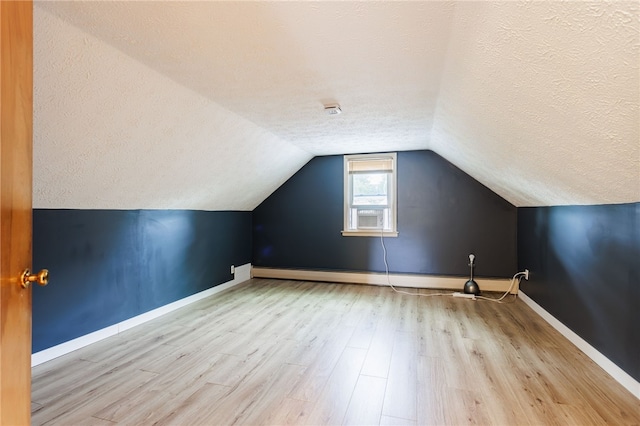 773 Marshall Rd, Chili, NY 14624 - additional living space with a textured ceiling, wood finished floors, vaulted ceiling, and a baseboard radiator
