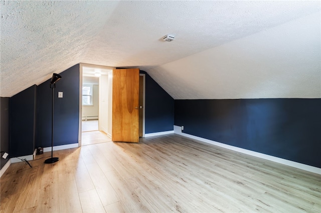 773 Marshall Rd, Chili, NY 14624 - additional living space with a textured ceiling, wood finished floors, vaulted ceiling, and a baseboard radiator