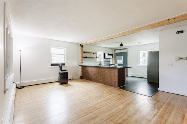 773 Marshall Rd, Chili, NY 14624 - kitchen with stainless steel appliances, a peninsula, wood finished floors, dark countertops, and open floor plan