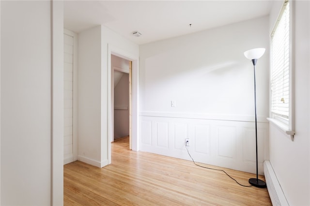 773 Marshall Rd, Chili, NY 14624 - unfurnished room featuring plenty of natural light, light wood-type flooring, and a baseboard heating unit