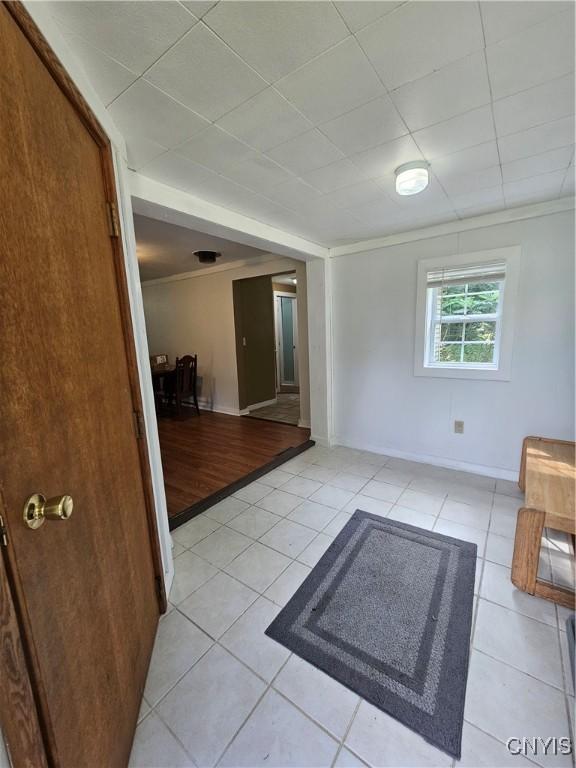 147 N St, Constantia, NY 13042 - unfurnished room with light tile patterned floors, ornamental molding, and a drop ceiling