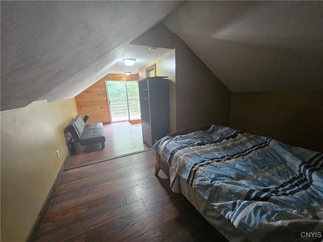 147 N St, Constantia, NY 13042 - bedroom with wood-type flooring, vaulted ceiling, wooden walls, and a textured ceiling