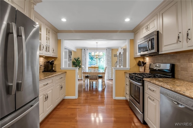 21 Towne Square Dr, Lancaster, NY 14086 - kitchen with stainless steel appliances, crown molding, a chandelier, backsplash, and light wood finished floors