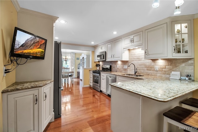 21 Towne Square Dr, Lancaster, NY 14086 - kitchen with appliances with stainless steel finishes, a peninsula, light wood-style floors, tasteful backsplash, and light stone counters