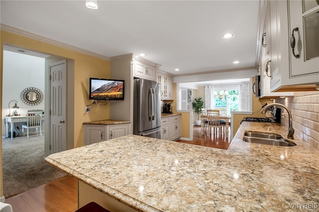 21 Towne Square Dr, Lancaster, NY 14086 - kitchen with appliances with stainless steel finishes, ornamental molding, a peninsula, light stone counters, and white cabinetry