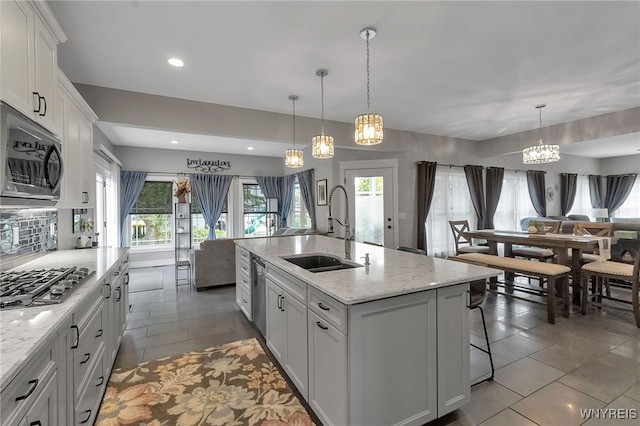 6132 Railroad St, Clarence, NY 14032 - kitchen featuring stainless steel appliances, tile patterned floors, white cabinets, a center island with sink, and pendant lighting