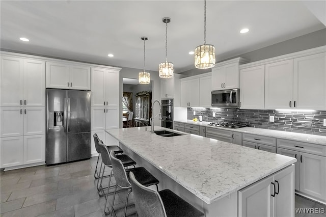6132 Railroad St, Clarence, NY 14032 - kitchen with stainless steel appliances, backsplash, white cabinetry, recessed lighting, and a kitchen island with sink