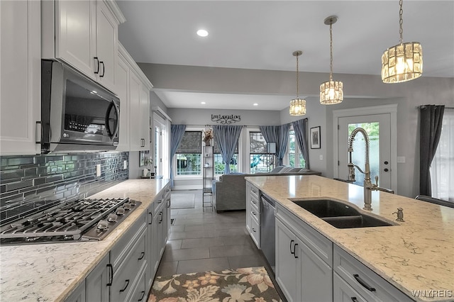 6132 Railroad St, Clarence, NY 14032 - kitchen with appliances with stainless steel finishes, a chandelier, recessed lighting, backsplash, and light stone counters