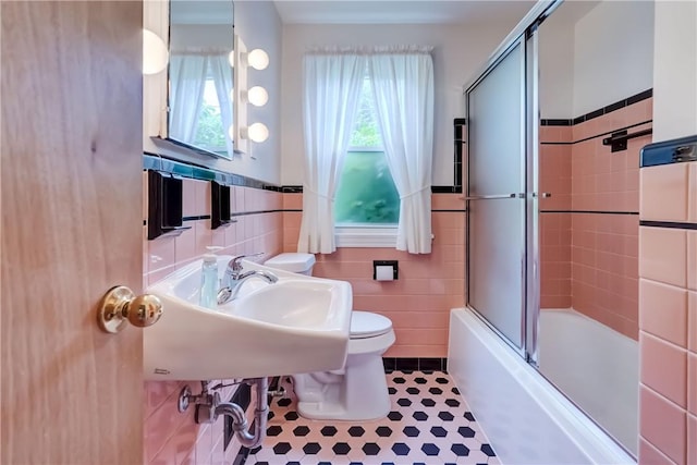 3201 Elmwood Ave, Brighton, NY 14618 - bathroom featuring tile walls, bath / shower combo with glass door, a wainscoted wall, and tile patterned flooring