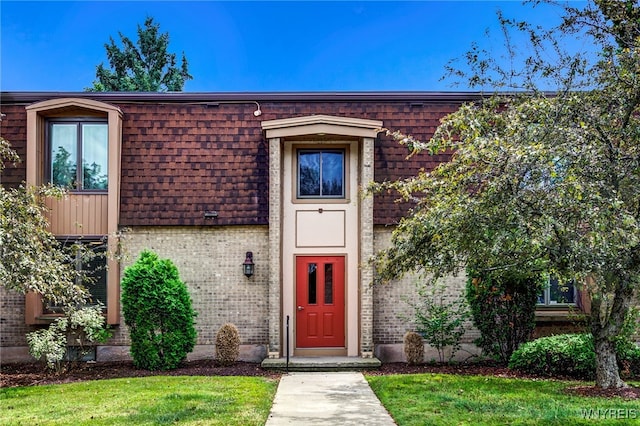 135 Charter Oaks Dr Unit 1, Amherst, NY 14228 - property entrance with brick siding, mansard roof, and a lawn