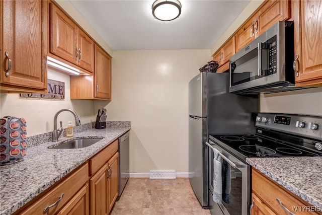 135 Charter Oaks Dr Unit 1, Amherst, NY 14228 - kitchen featuring stainless steel appliances, light stone countertops, and brown cabinets