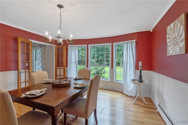 134 County Route 23a, Constantia, NY 13044 - dining area featuring a baseboard heating unit, a chandelier, crown molding, and light wood-type flooring