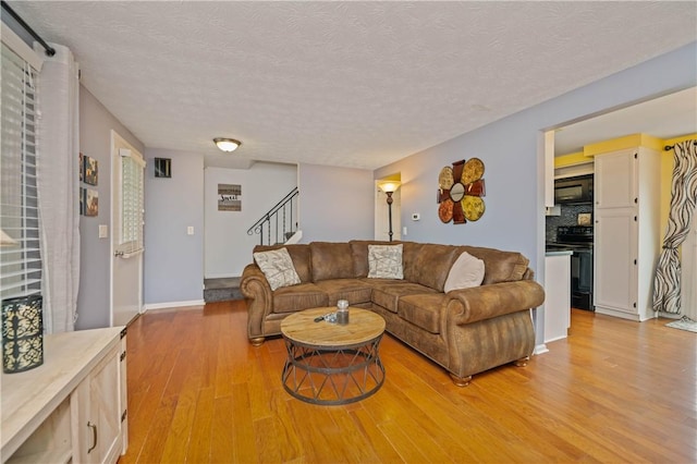 24 Huntsman, Webster, NY 14580 - living room featuring light wood-type flooring, a textured ceiling, and stairs
