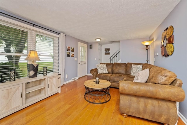 24 Huntsman, Webster, NY 14580 - living area featuring light wood finished floors, stairs, and a textured ceiling