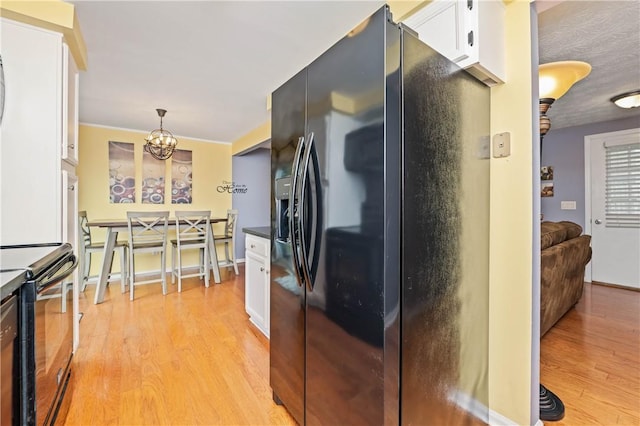 24 Huntsman, Webster, NY 14580 - kitchen featuring black appliances, white cabinets, light wood-style floors, dark countertops, and a chandelier